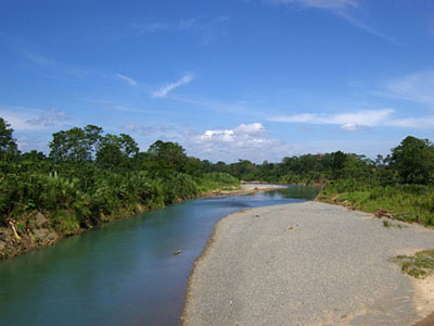 Fluss mit klarem Wasser, umgeben von üppiger Vegetation und blauem Himmel in Costa Rica